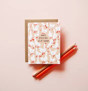 Happy Ducking Birthday Card by Badger & Burke featuring illustrated white ducks on a peach background with a kraft envelope.