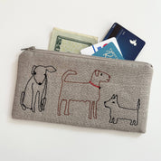 Dogs Pouch by K Studio in natural flax linen with embroidered line-drawn dogs, quilted construction, zippered closure, and dotted cotton lining.