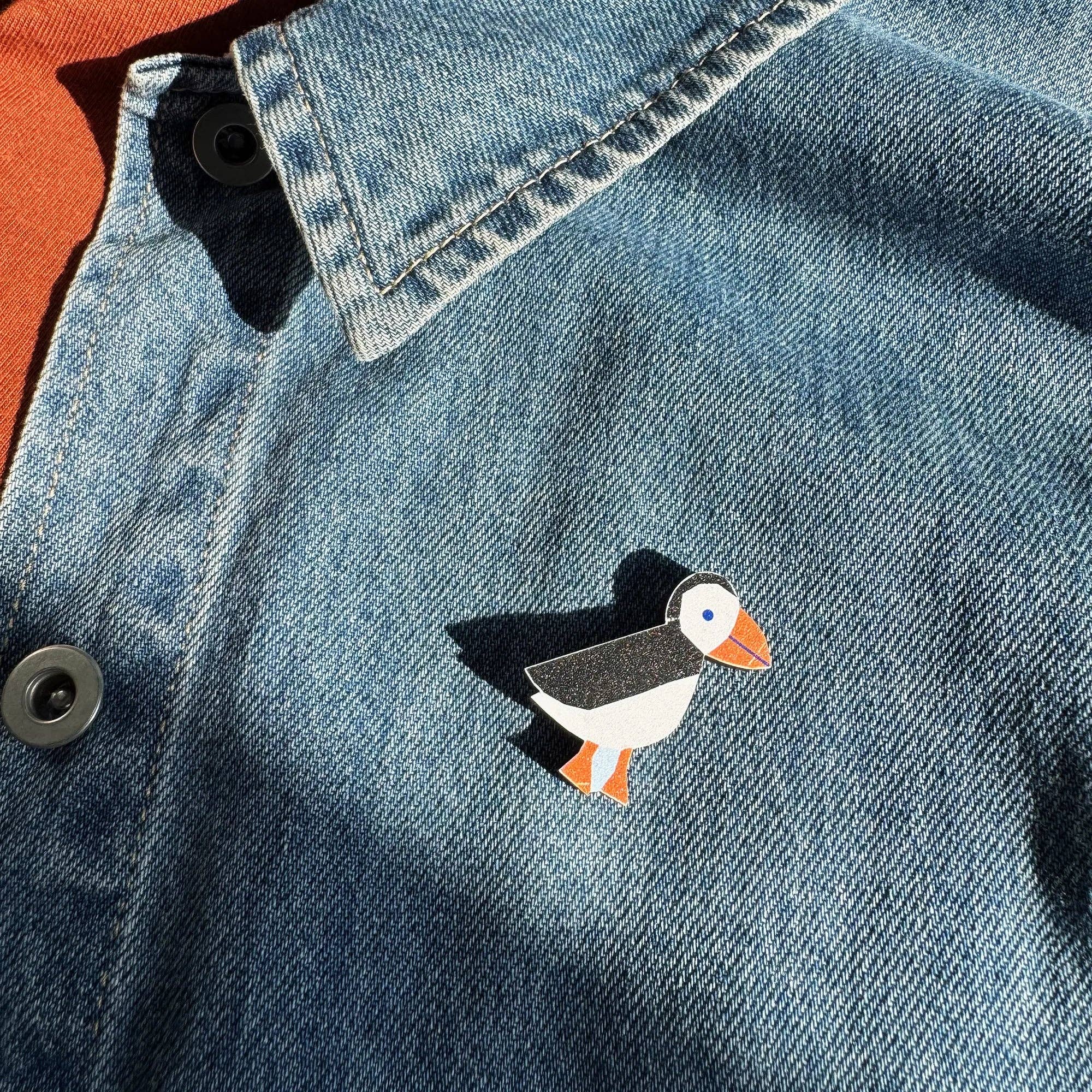Kauniste Puffin Pin, a sustainable maple wooden pin featuring a black-and-white Atlantic puffin with orange beak and feet.