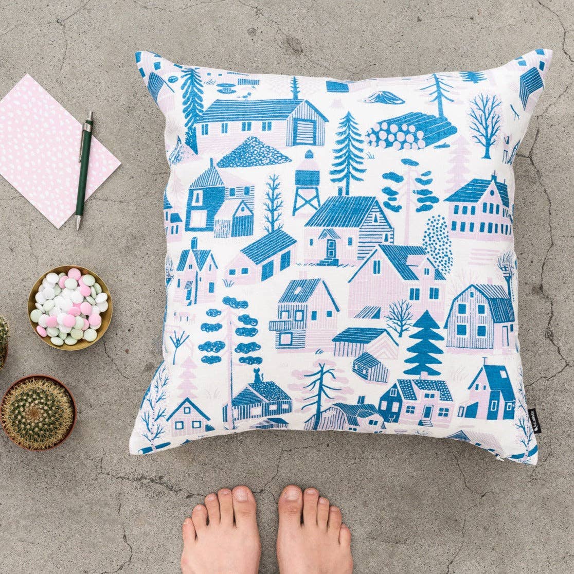 Mökkilä Cushion Cover featuring a playful Nordic village pattern by Bjørn Rune Lie in linen-cotton fabric with hidden zipper closure.
