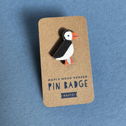 Kauniste Puffin Pin, a sustainable maple wooden pin featuring a black-and-white Atlantic puffin with orange beak and feet.