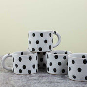 Blot Coffee Cup in matte light grey stoneware with glossy black dots. Handmade in Nepal, fair trade.