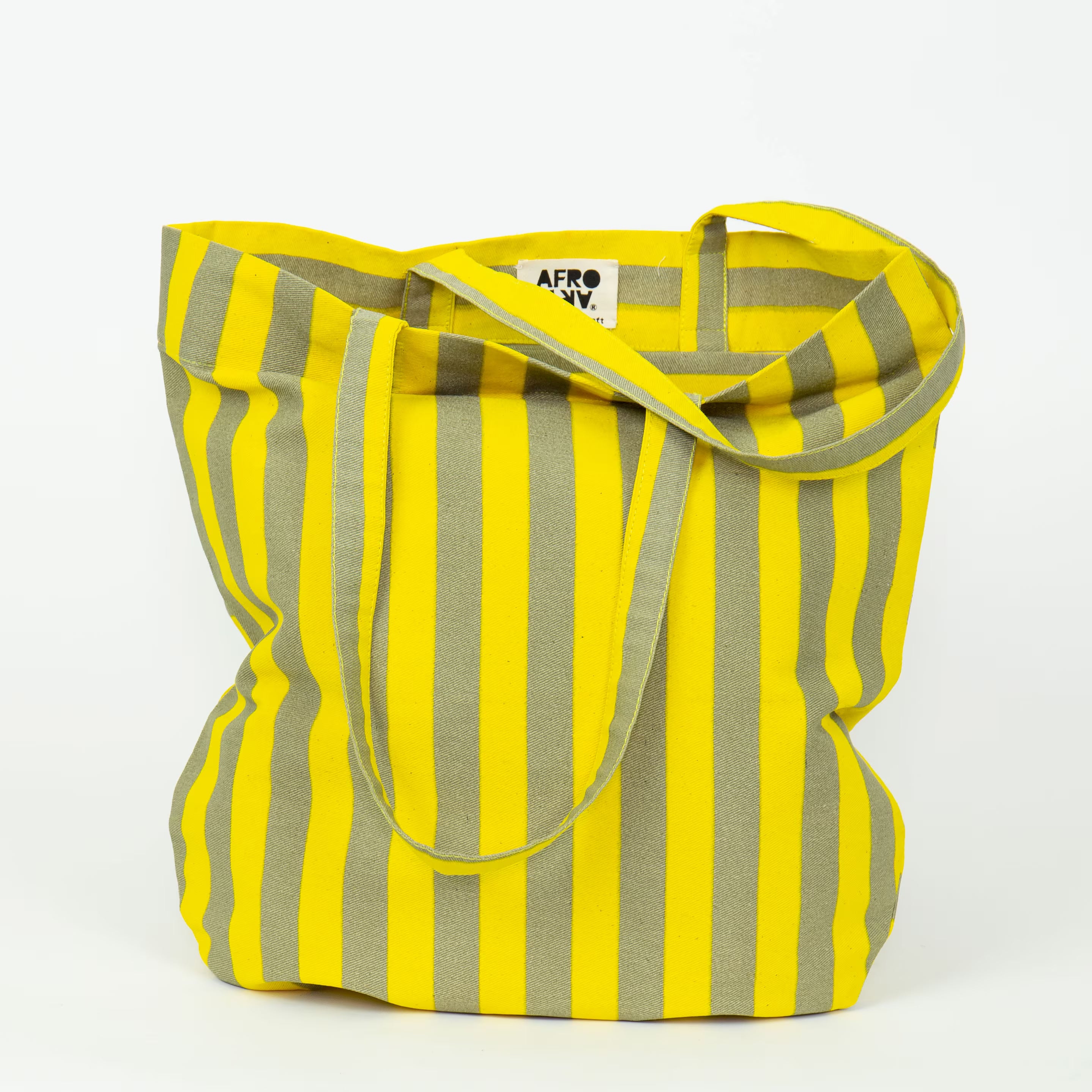 Randa cotton tote bag by A World of Craft with hand-printed stripes, showing vertical stripes on one side and horizontal stripes on the other, featuring shoulder-length straps and a zippered inner pocket.