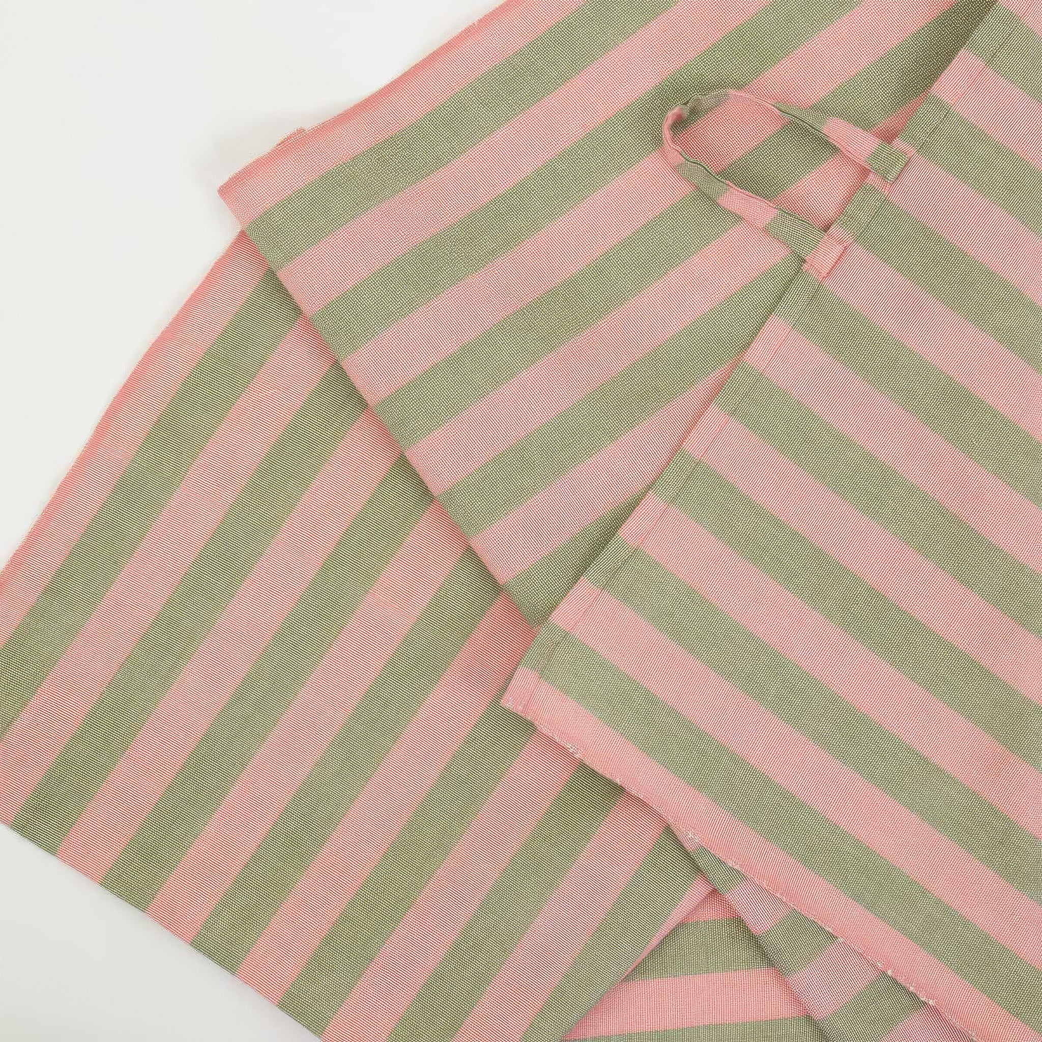 Martina Kitchen Towel by A World of Craft with wide coral and olive green handwoven cotton stripes, folded to showcase the textured reps weave and bold striped pattern.