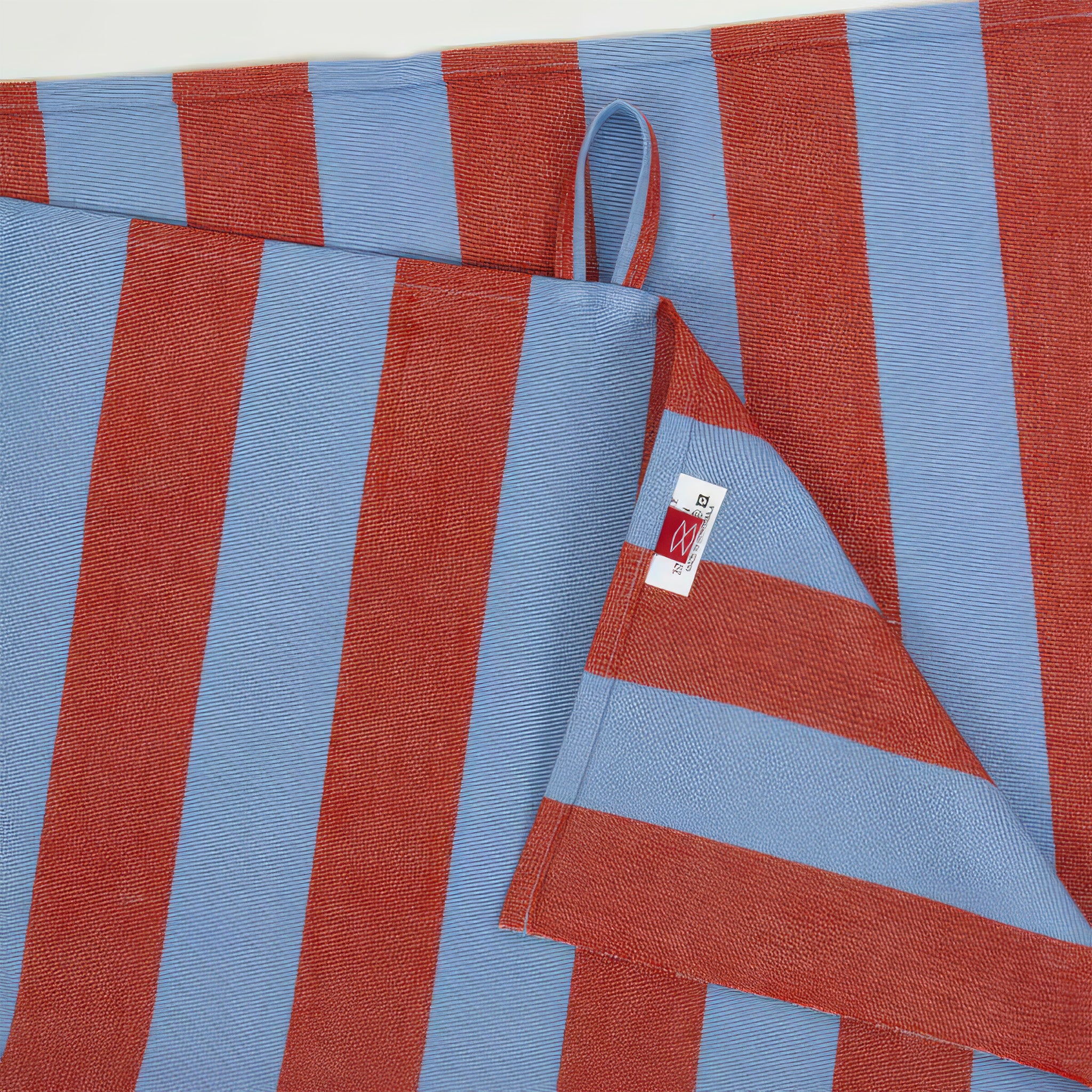 Nora Kitchen Towel by A World of Craft with wide blue and red handwoven cotton stripes, folded to show the bold striped pattern and textured reps weave.