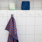 Zora Towel by A World of Craft in handwoven cotton with dark blue and brown vertical stripes.