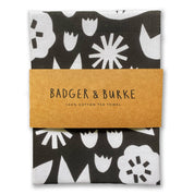 Badger & Burke June Floral Tea Towel. Bold black-and-white floral cotton towel with hanging loop. Pairs perfectly with the June Birch Tray.