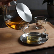 Kinto CARAT glass teapot with stainless steel conical filter, available in 600 ml and 850 ml sizes, shown brewing loose-leaf tea.