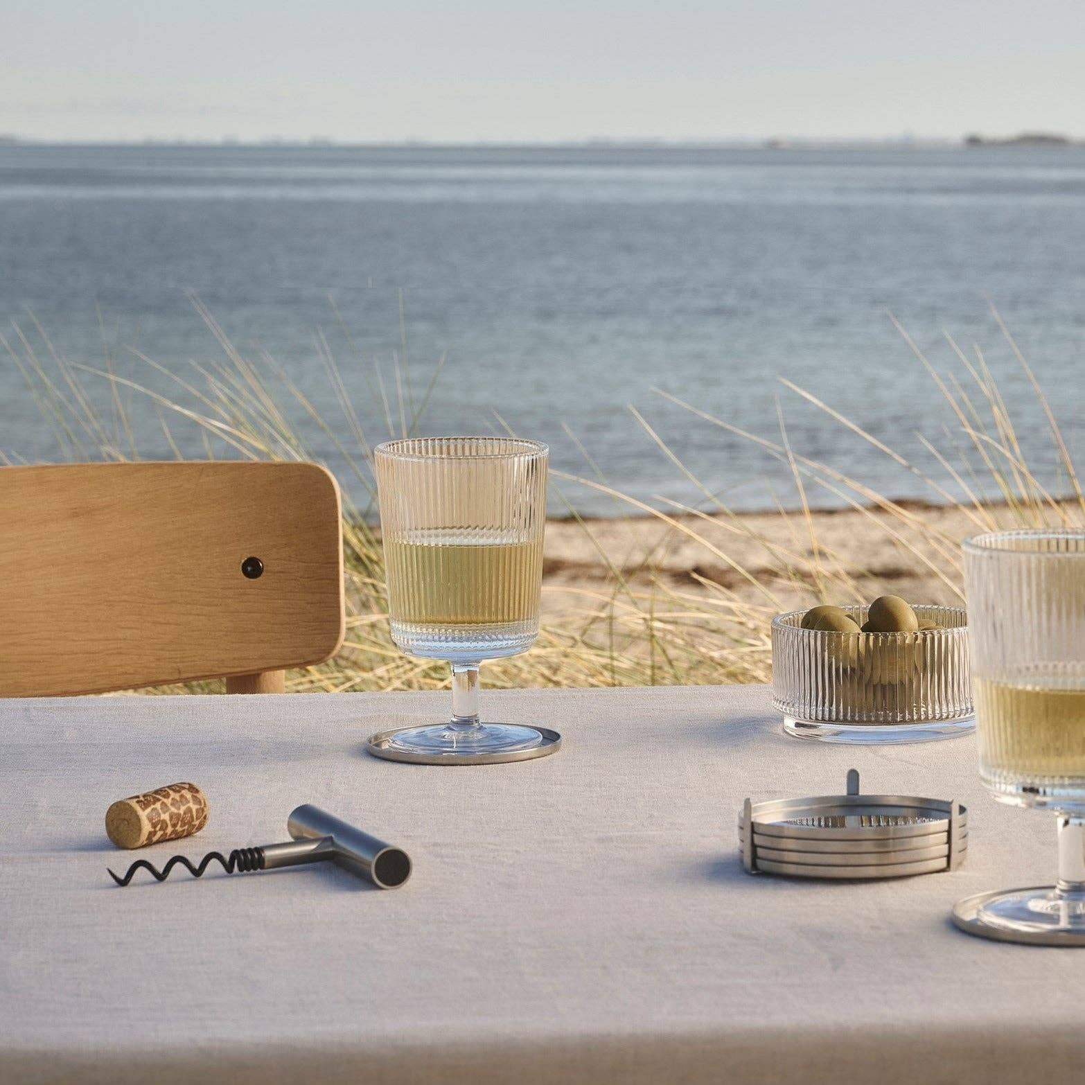 Pilastro Wine Glass Set by Stelton with four clear ribbed wine glasses featuring an Art Deco-inspired design and footed base.