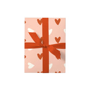 Hearts 2 Gift Wrap by Dahlia Press with pink and white heart pattern, shown wrapped around a gift and tied with a coordinating ribbon.