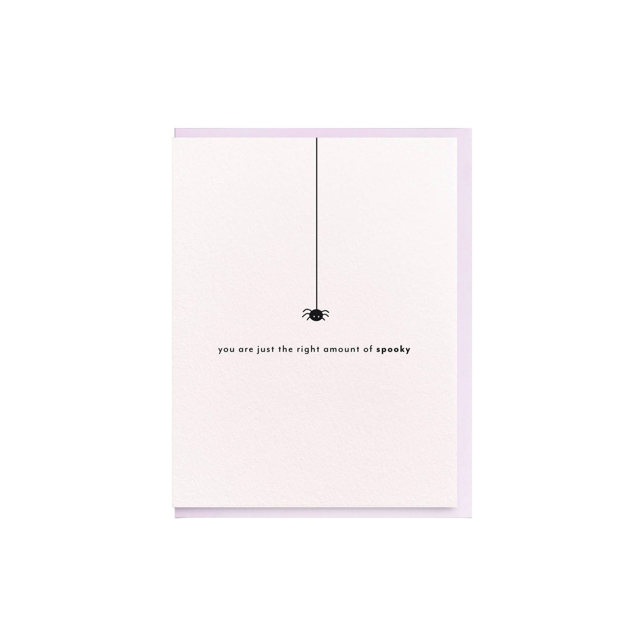 Spooky Spider Card by Dahlia Press featuring a tiny black spider dangling above the message “you are just the right amount of spooky” on a pale pink card.