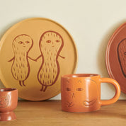 Donna Wilson Cat Mug in warm terracotta with debossed cat illustrations and chunky rounded handle.