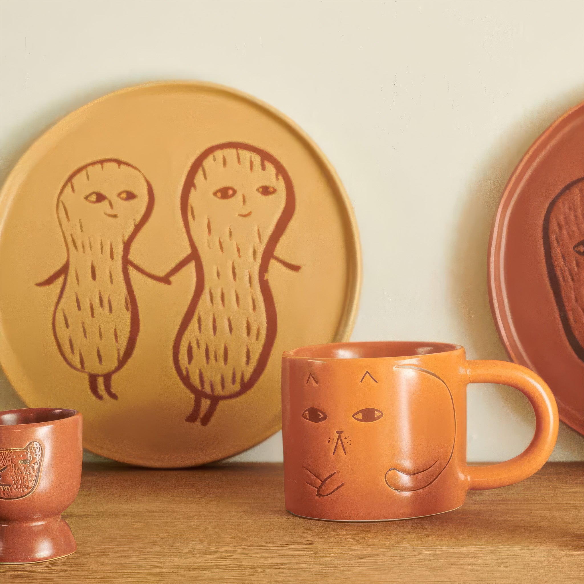 Donna Wilson Cat Mug in warm terracotta with debossed cat illustrations and chunky rounded handle.
