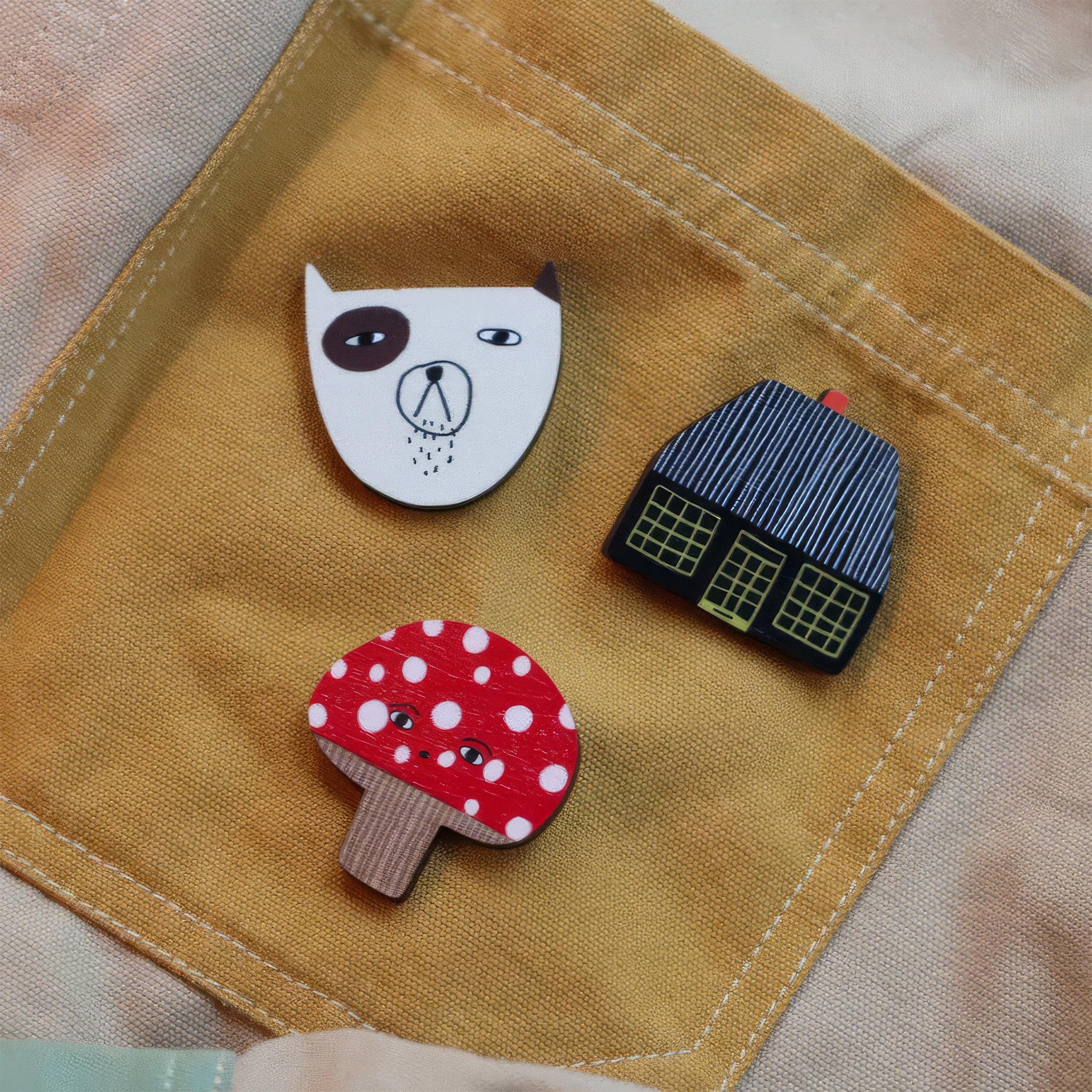 Donna Wilson Toadie Brooch Pin featuring a red and white spotted mushroom character with a friendly face, made from sustainably sourced beech wood with a metal butterfly clutch backing.
