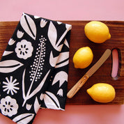 Badger & Burke June Floral Tea Towel. Bold black-and-white floral cotton towel with hanging loop. Pairs perfectly with the June Birch Tray.