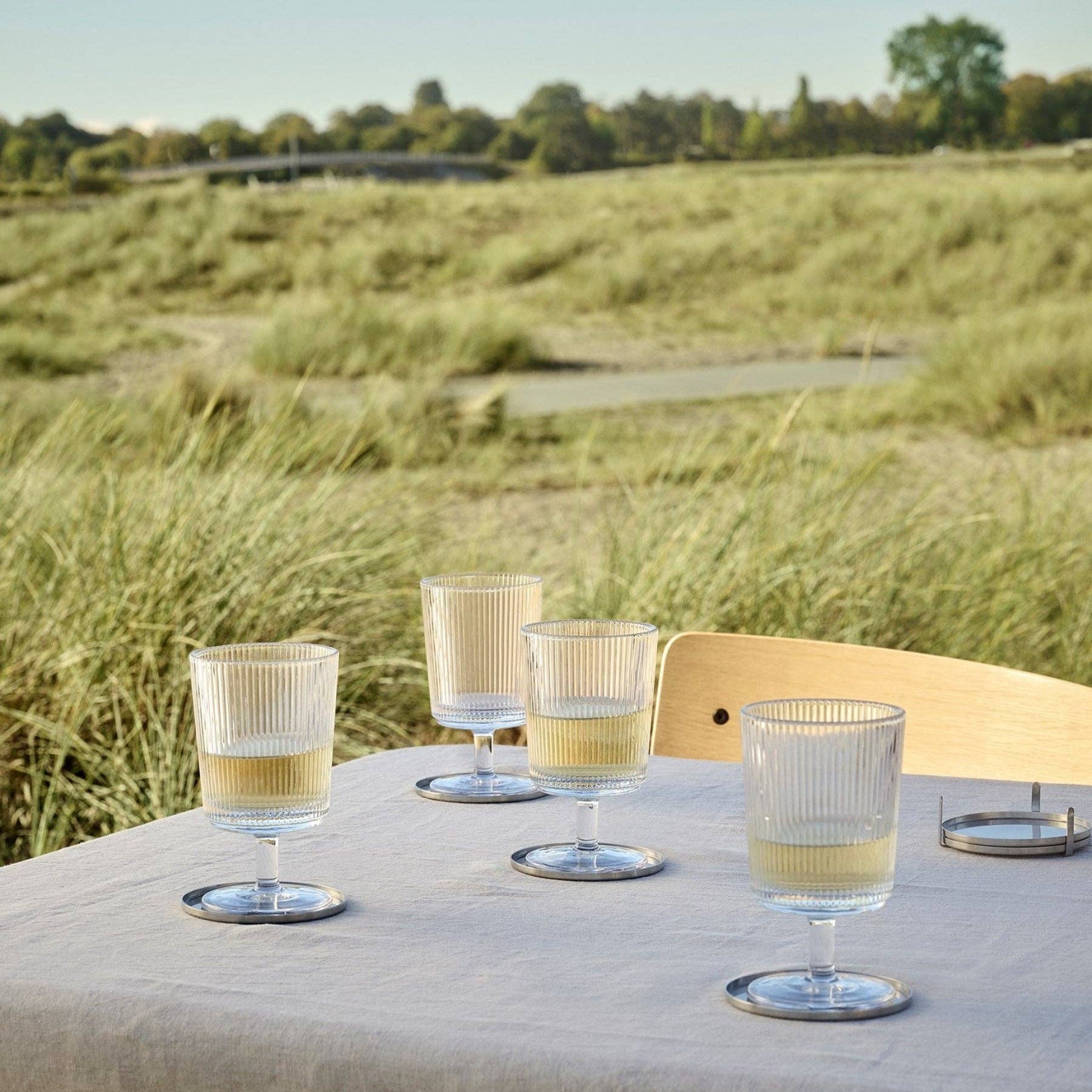 Pilastro Wine Glass Set by Stelton with four clear ribbed wine glasses featuring an Art Deco-inspired design and footed base.