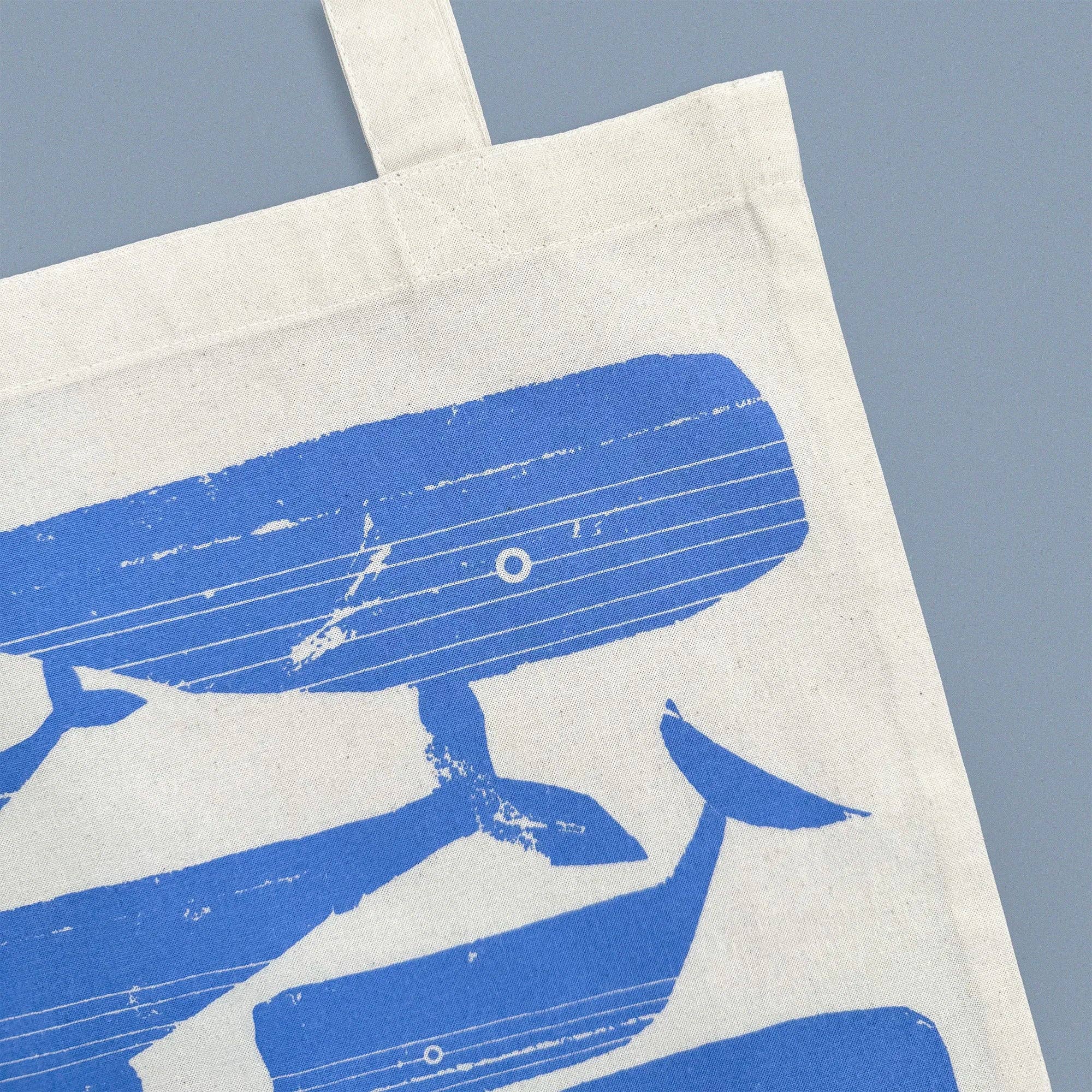 Whale Pod Tote Bag by Kautzi Illustrations with periwinkle blue whales screen-printed on natural cotton.