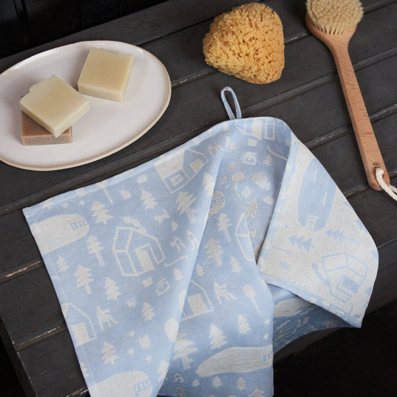 Sauna Towel by Kauniste in reversible cotton-linen jacquard fabric featuring a Finnish lakeside sauna and forest pattern designed by Riikka Laakso.