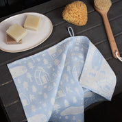 Sauna Towel by Kauniste in reversible cotton-linen jacquard fabric featuring a Finnish lakeside sauna and forest pattern designed by Riikka Laakso.