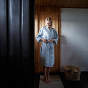 Sauna Robe by Kauniste in reversible cotton-linen jacquard with Riikka Laakso’s Finnish sauna, lake, and forest pattern.