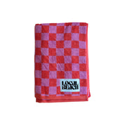 Local Beach Checker Beach Towels in coral/lavender checkerboard pattern. Made from heavyweight 100% cotton jacquard terry for soft, absorbent comfort at the beach, lake, pool, or bath.