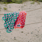 Local Beach Checker Beach Towels in coral/lavender checkerboard pattern. Made from heavyweight 100% cotton jacquard terry for soft, absorbent comfort at the beach, lake, pool, or bath.