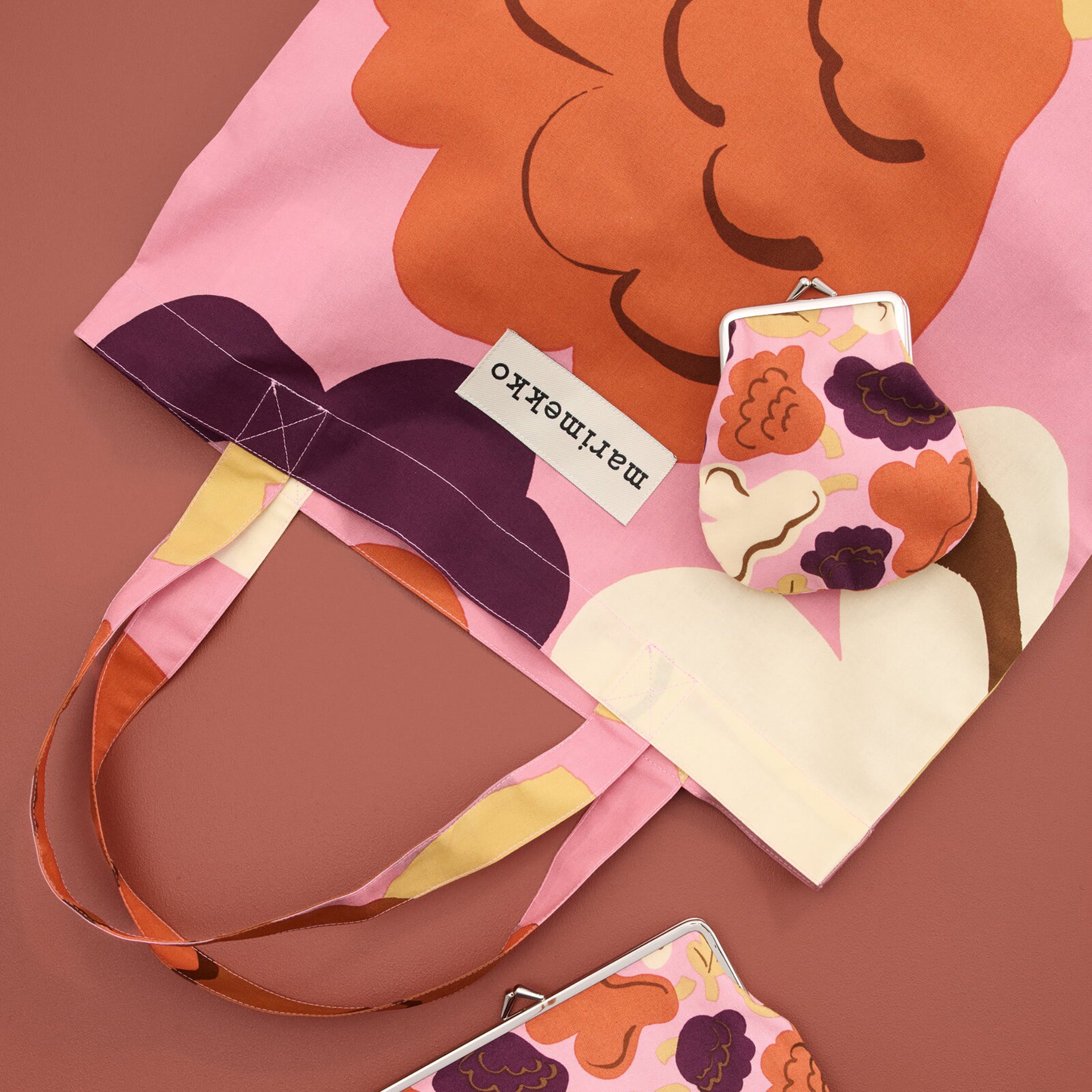 Marimekko Kukasta Kukkaan Tote Bag in pink, plum, terracotta, and off-white with oversized floral pattern by Erja Hirvi.
