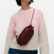 Marimekko Pikku Karla Shoulder Bag in smooth leather with a sculptural candy wrapper-inspired shape, adjustable shoulder strap, and zip closure.