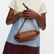 Marimekko Pikku Karla Shoulder Bag in smooth leather with a sculptural candy wrapper-inspired shape, adjustable shoulder strap, and zip closure.