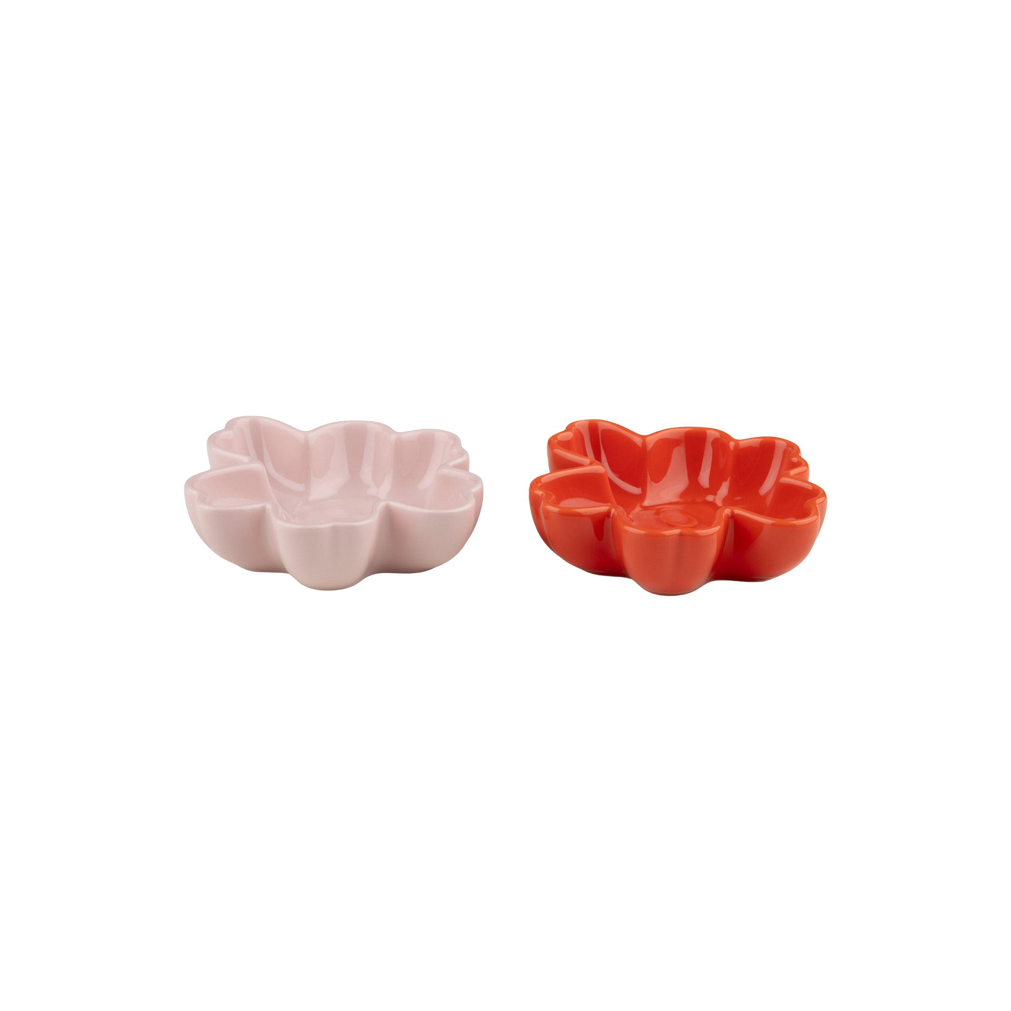 Set of two Marimekko Unikko small flower-shaped ceramic bowls in pink and orange red glaze, viewed from above on a neutral background.