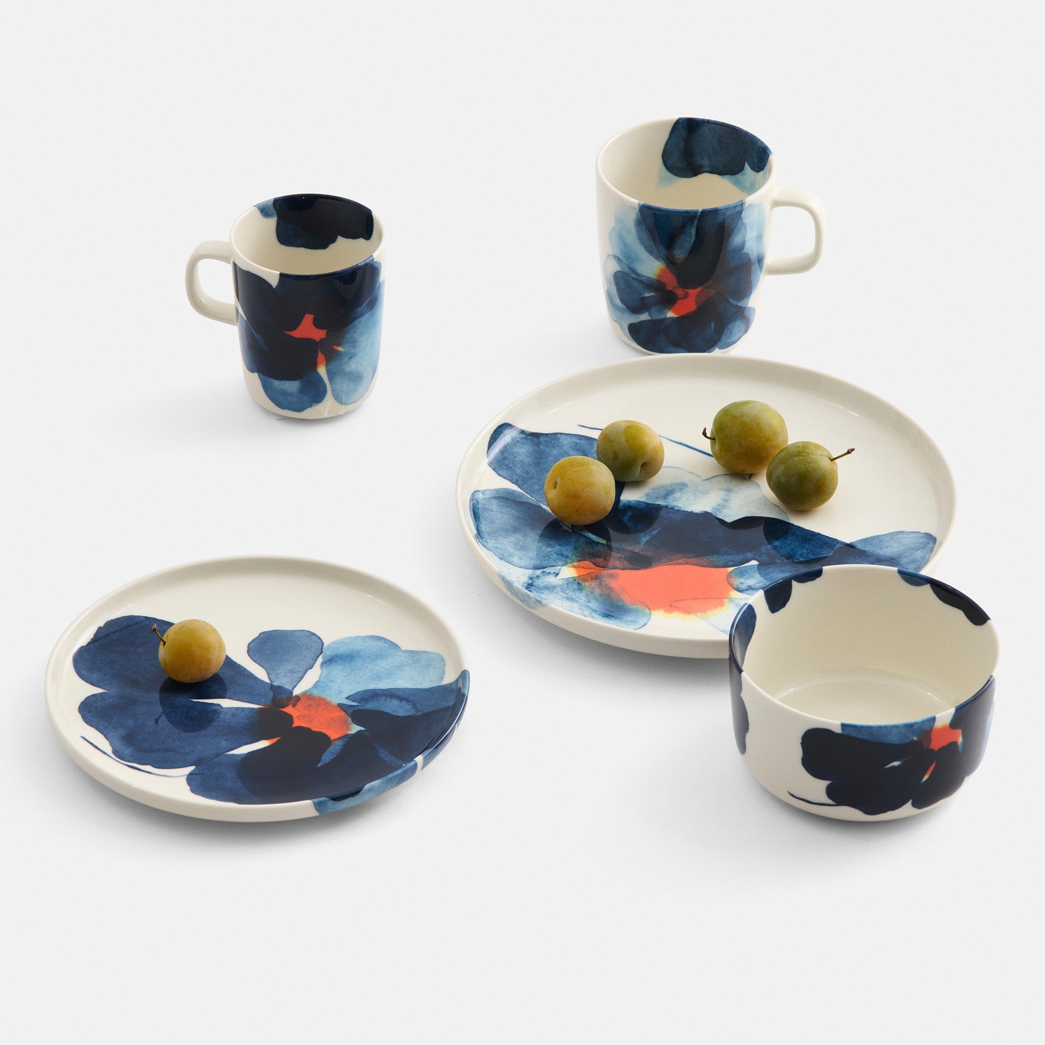 Marimekko Valssi Dinnerware with bold floral print in blue and orange on white stoneware.