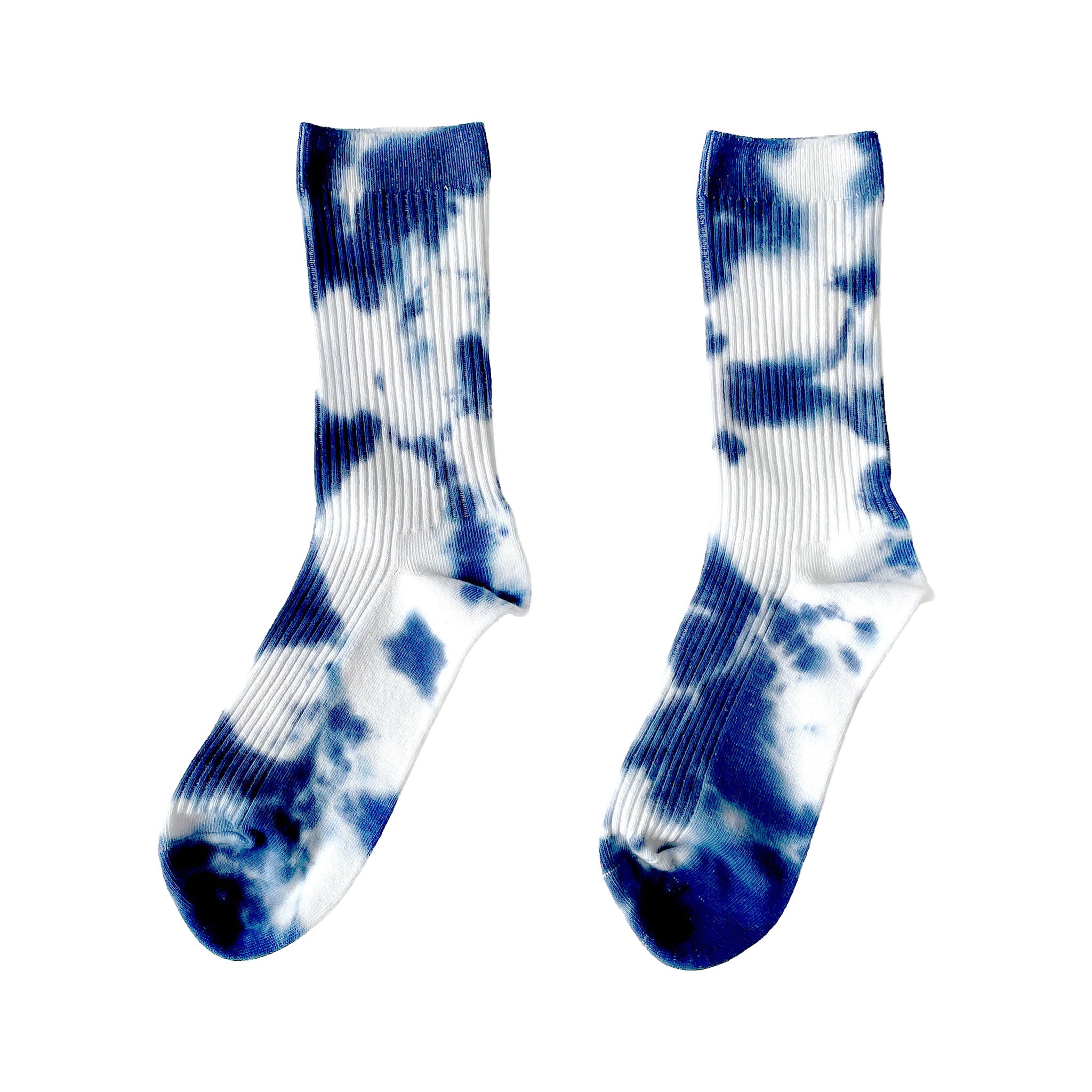 Indigo Tie-Dye Dressy Socks by Merle Works featuring white ribbed cotton with bold, irregular indigo blue hand-dyed patterns, arranged as an overlapping pair.