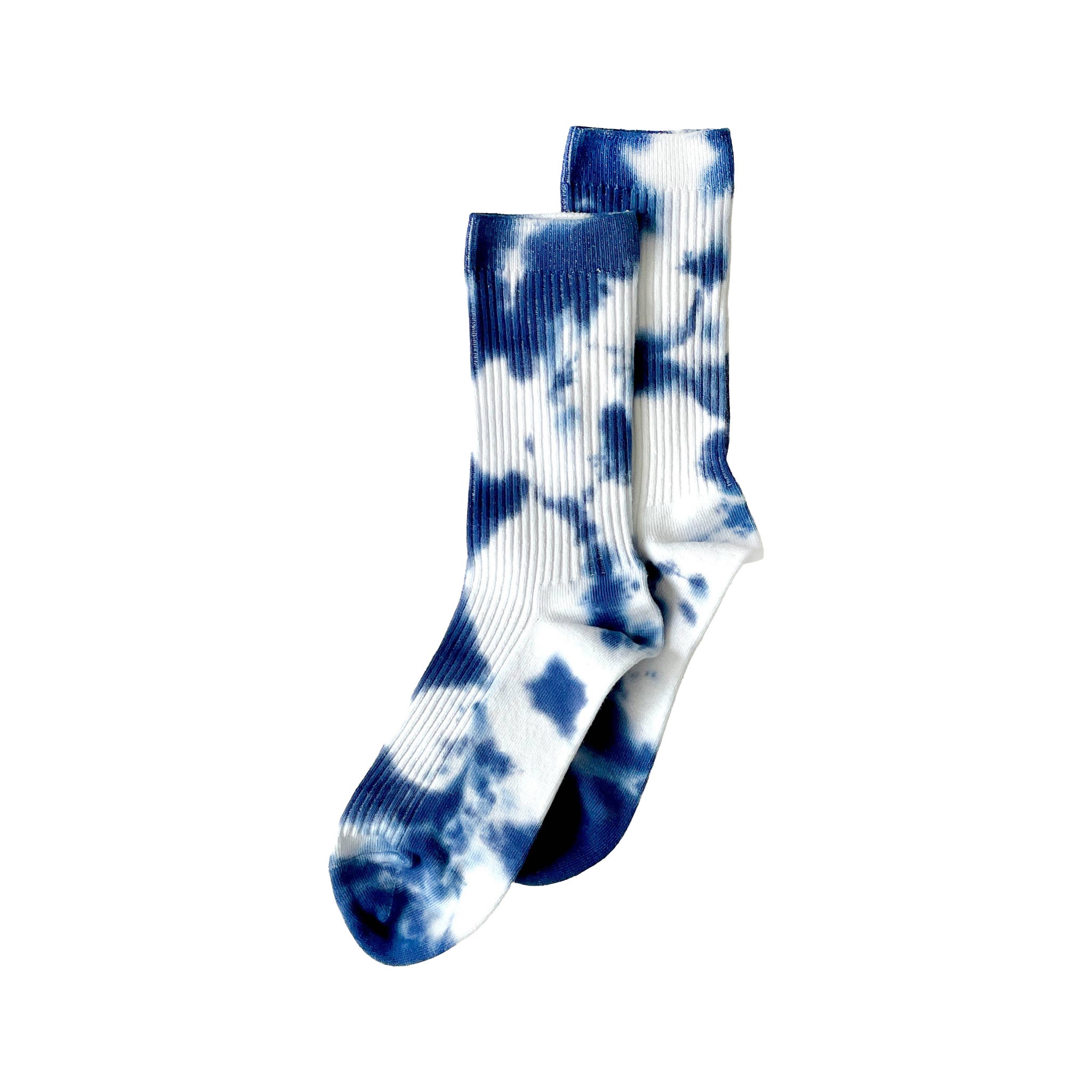 Indigo Tie-Dye Dressy Socks by Merle Works featuring white ribbed cotton with bold, irregular indigo blue hand-dyed patterns, arranged as an overlapping pair.