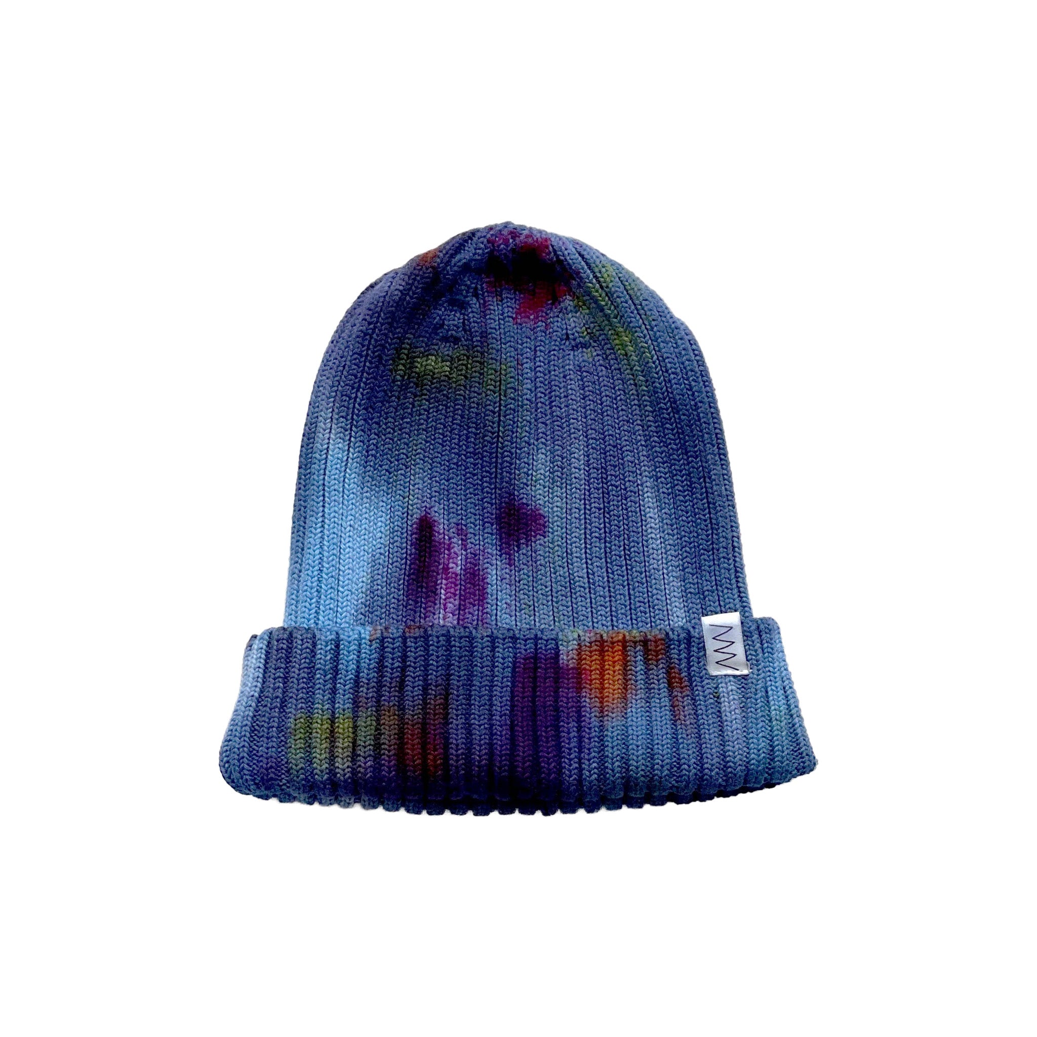 Painter's Hand-Dyed Beanie Hat by Merle Works in rich blue ribbed cotton-blend knit with hand-dyed splashes of purple, green, orange, and magenta, featuring a folded cuff and woven logo tag.