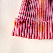 Shortcake Hand-Dyed Beanie Hat by Merle Works in strawberry pink with apricot, coral, and raspberry accents, featuring a ribbed cotton-blend knit, folded cuff, and woven logo tag.