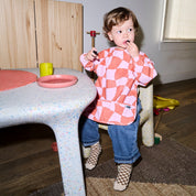 Long sleeve smock bib in six artist-designed colorways. Waterproof, recycled fabric, fits 6 months–3 years—extra coverage for mealtime and crafts.