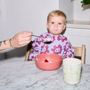 Long sleeve smock bib in six artist-designed colorways. Waterproof, recycled fabric, fits 6 months–3 years—extra coverage for mealtime and crafts.
