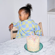 Long sleeve smock bib in six artist-designed colorways. Waterproof, recycled fabric, fits 6 months–3 years—extra coverage for mealtime and crafts.