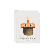 Red Cap Cards A Cake Card by Jon Klassen featuring an orange cupcake with eyes and a single birthday candle.