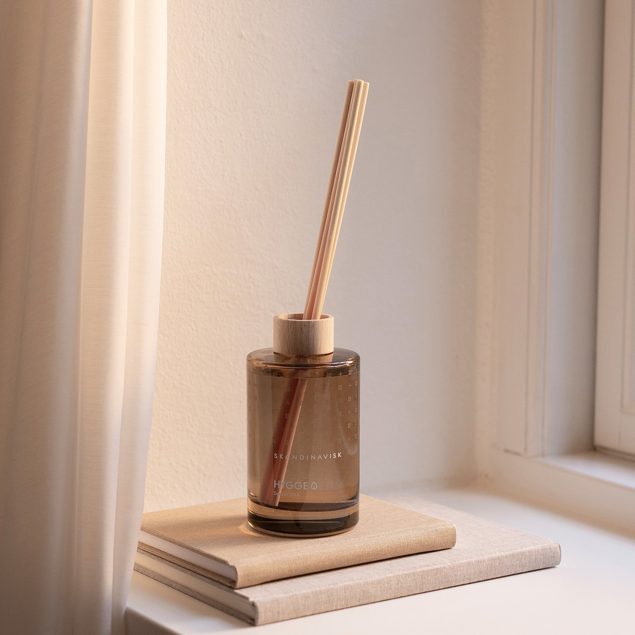 Skandinavisk Hygge 200ml scent diffuser in painted glass bottle with wooden ring and reeds.