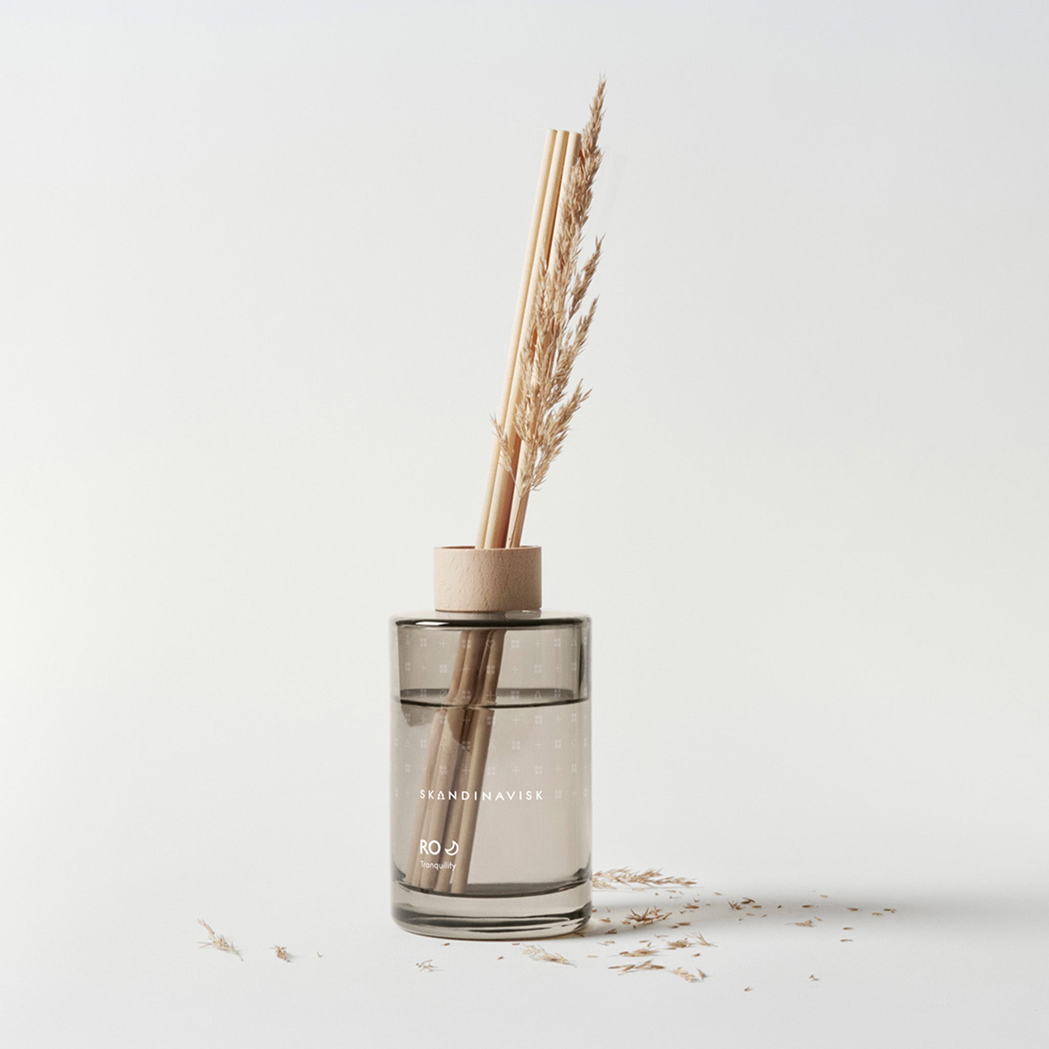 Ro Scent Diffuser by Skandinavisk with Scandinavian-inspired fragrance notes of cut grass, cucumber, wild violets, and fallen leaves in a minimalist glass diffuser vessel.