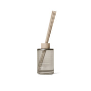 Ro Scent Diffuser by Skandinavisk with Scandinavian-inspired fragrance notes of cut grass, cucumber, wild violets, and fallen leaves in a minimalist glass diffuser vessel.