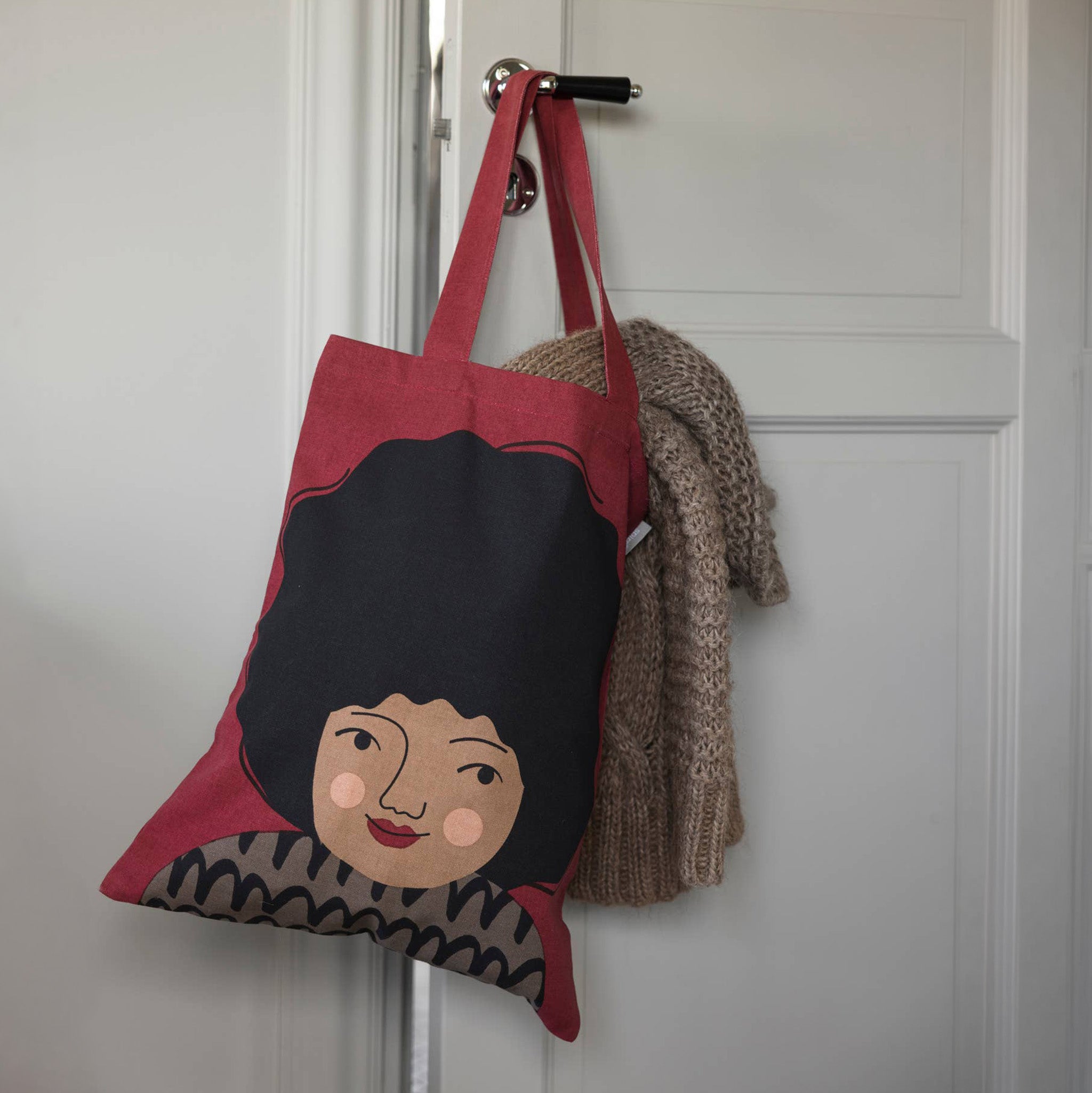 Spira of Sweden Hedvig Kompiskasse Tote Bag in deep red cotton with hand-printed Hedvig illustration and black hair.