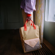 Sticky Lemon Envelope Backpack in colorful recycled fabric with front zip pocket, waterproof lining, and adjustable shoulder straps. Available in Small, Medium, and Large.