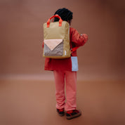 Sticky Lemon Envelope Backpack in colorful recycled fabric with front zip pocket, waterproof lining, and adjustable shoulder straps. Available in Small, Medium, and Large.