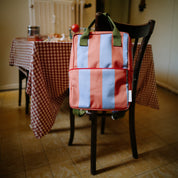 Sticky Lemon Stripes Backpack in colorful striped recycled fabric with front zip pocket, waterproof lining, and adjustable shoulder straps in Medium and Large.