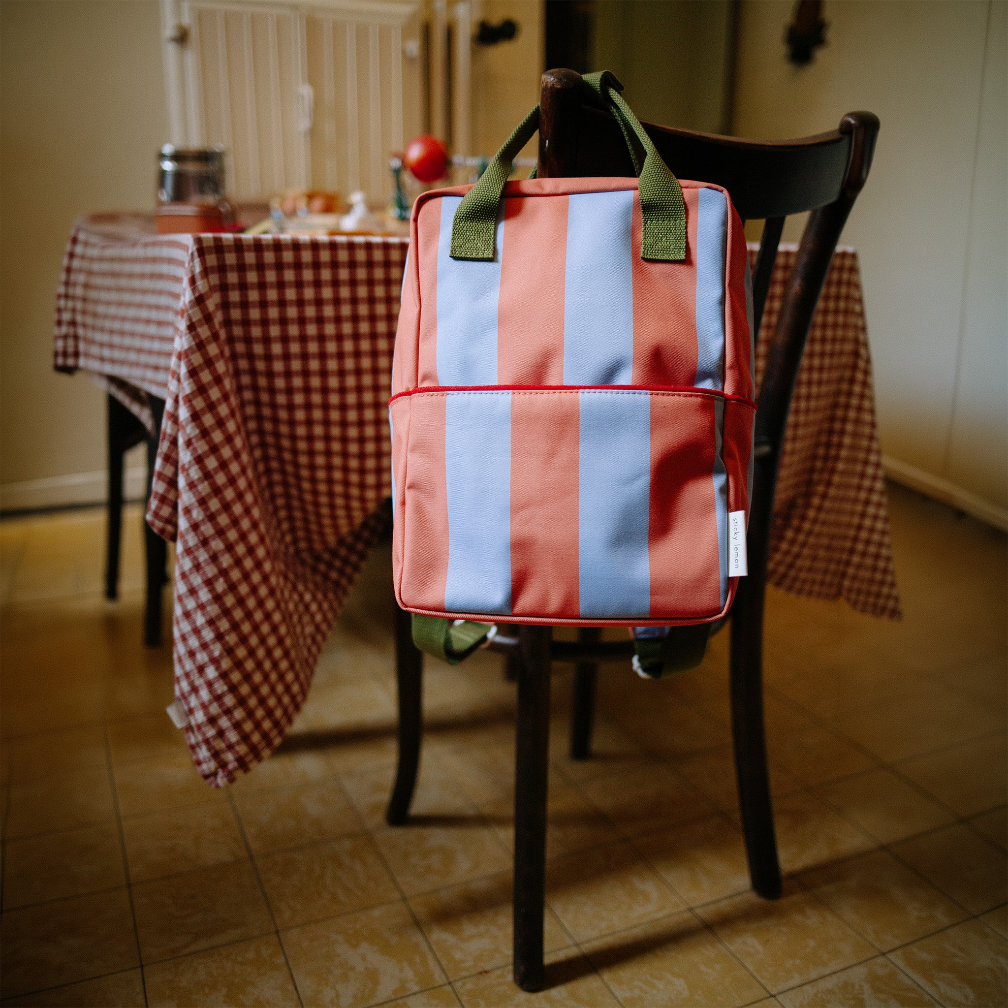 Sticky Lemon Stripes Backpack in colorful striped recycled fabric with front zip pocket, waterproof lining, and adjustable shoulder straps in Medium and Large.