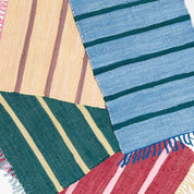 Upcycled Rug by Tarta Gelatina with colorful woven stripes and fringed ends, designed in Barcelona and handmade from upcycled cotton textiles.