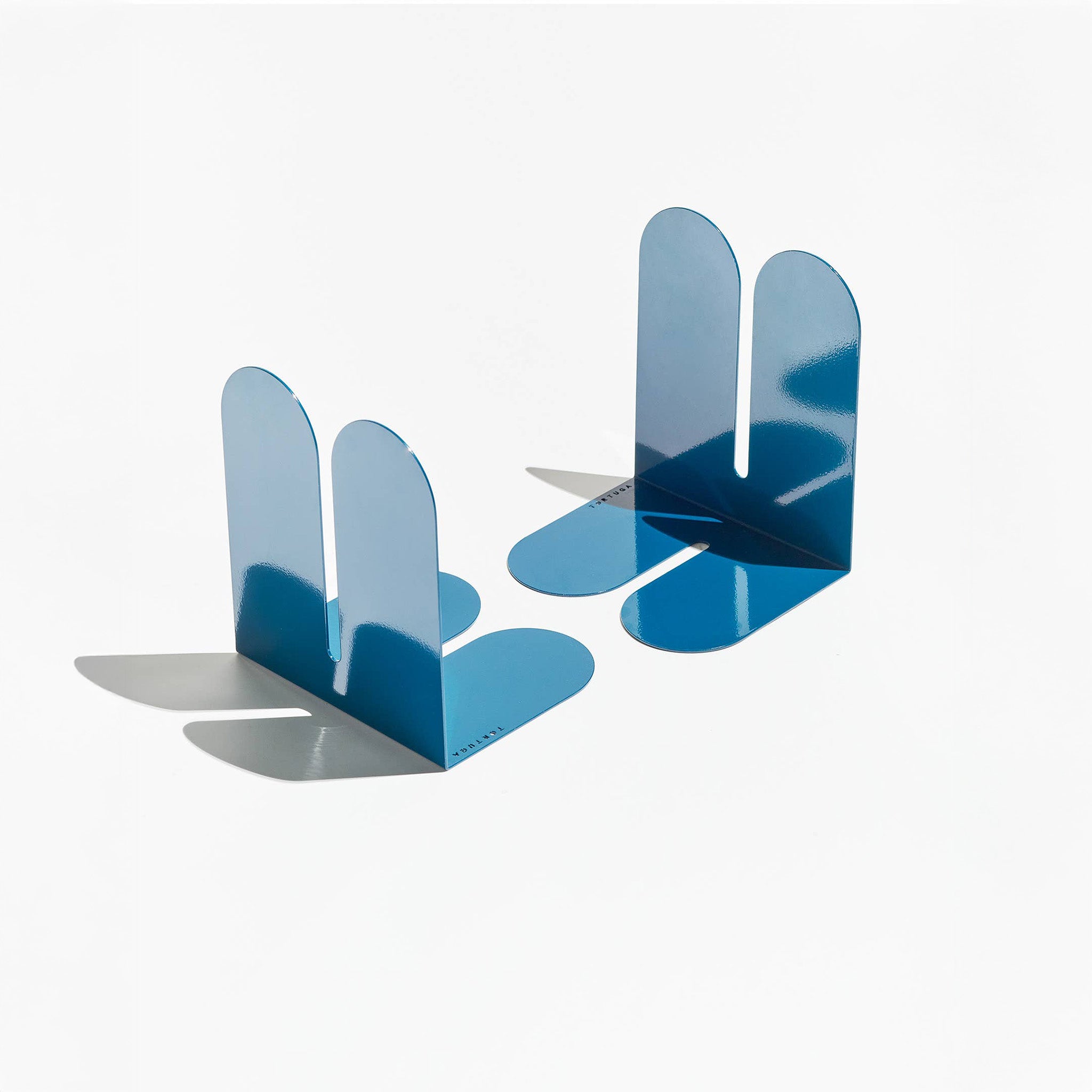 Tortuga Forma Large Bookend in abyss blue solid steel, oversized arc design for supporting heavy art books, cookbooks, and vinyl.