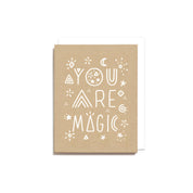 Worthwhile Paper You Are Magic Card with white hand-drawn lettering, stars, moons, and geometric doodles on kraft-colored recycled cardstock.